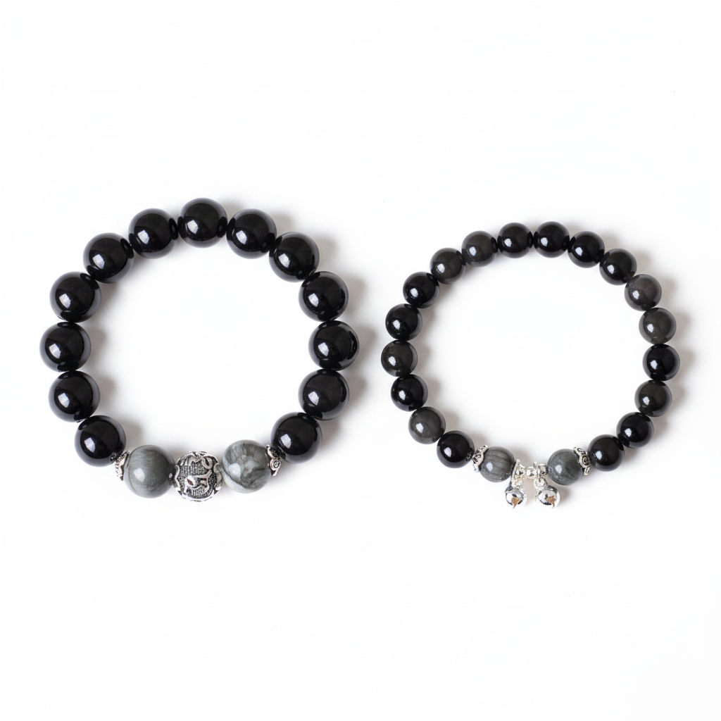 Close-up of black beads, gray natural accent beads, and silver charms