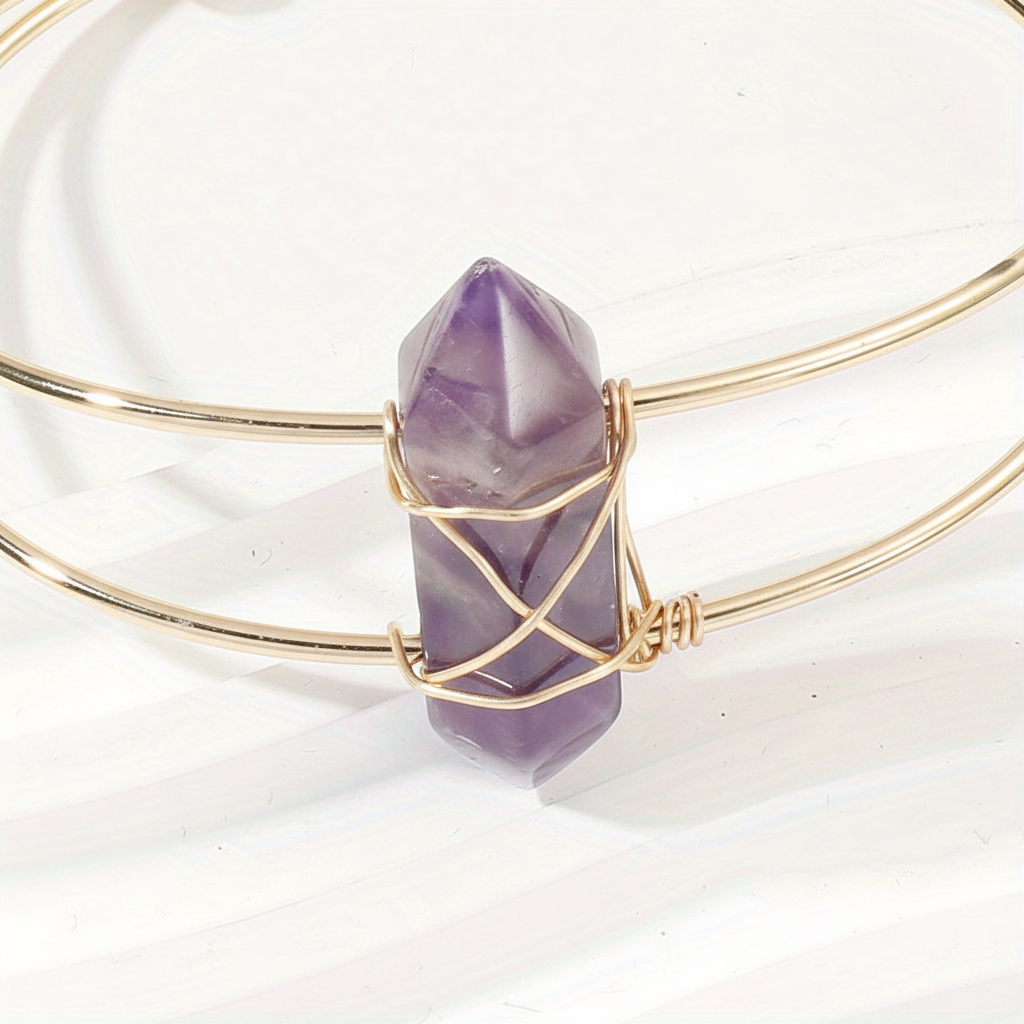 Close-up of purple faceted stone and gold wire wrapping