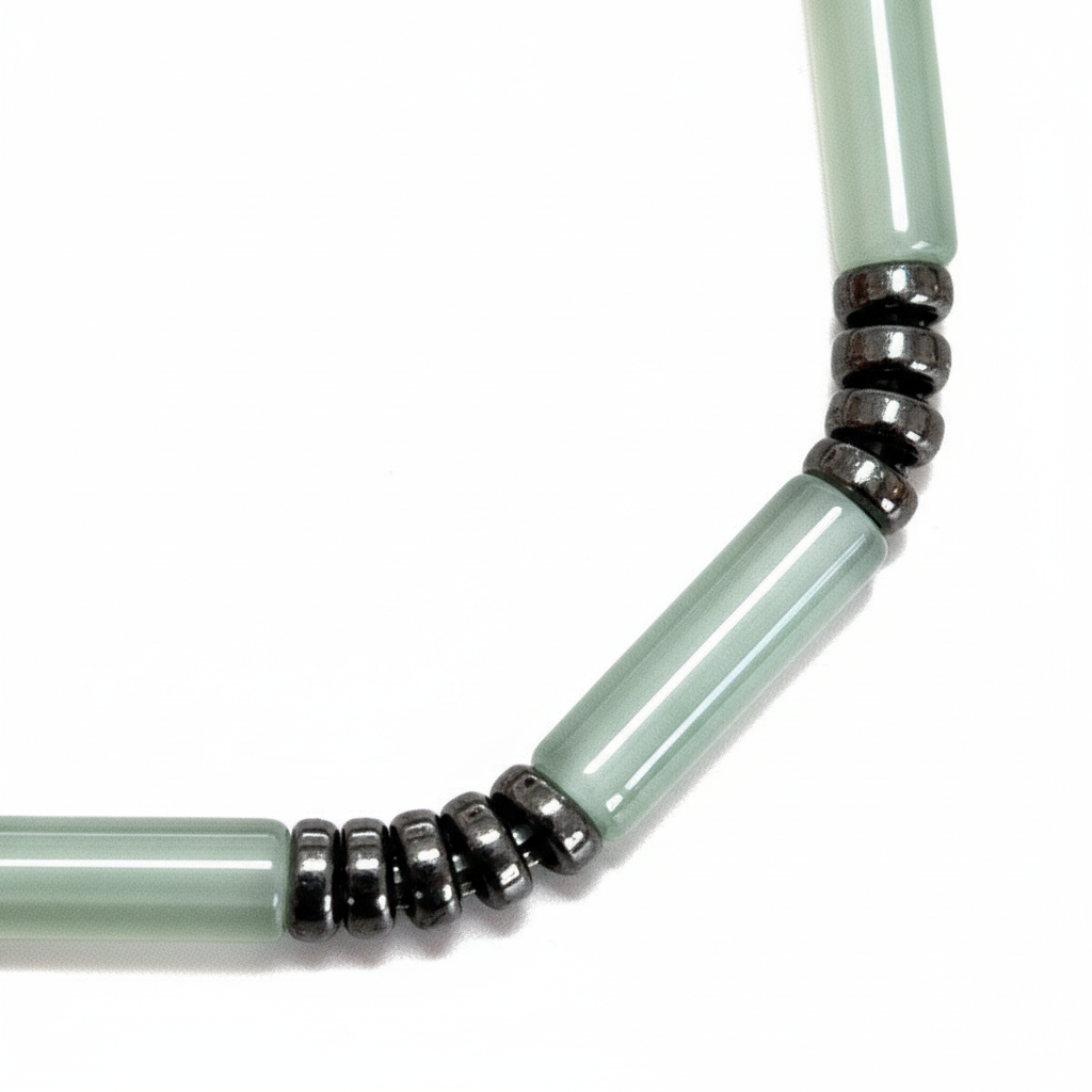 Close-up of pale mint green tube beads and black spacer rings