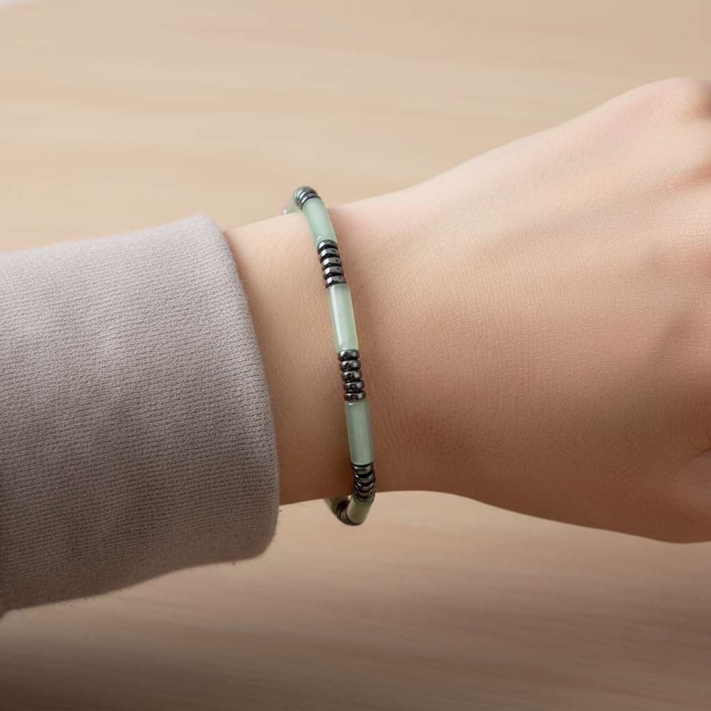 Pale mint green tube bead bracelet worn on a wrist